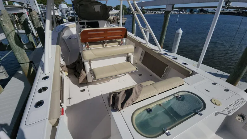 Slide: The Image of 2017 Pursuit S 280 Sport boat interior with seating and storage, docked by the water. - 44