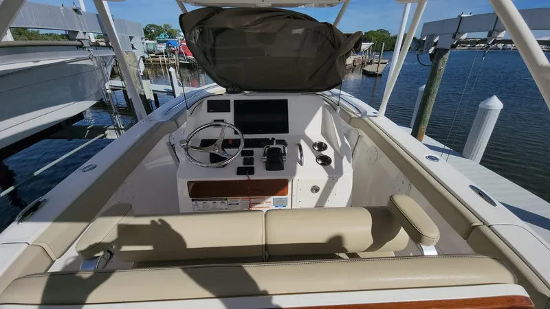 Slide: The Image of 2017 Pursuit S 280 Sport boat cockpit with steering wheel and controls, docked by the water. - 46