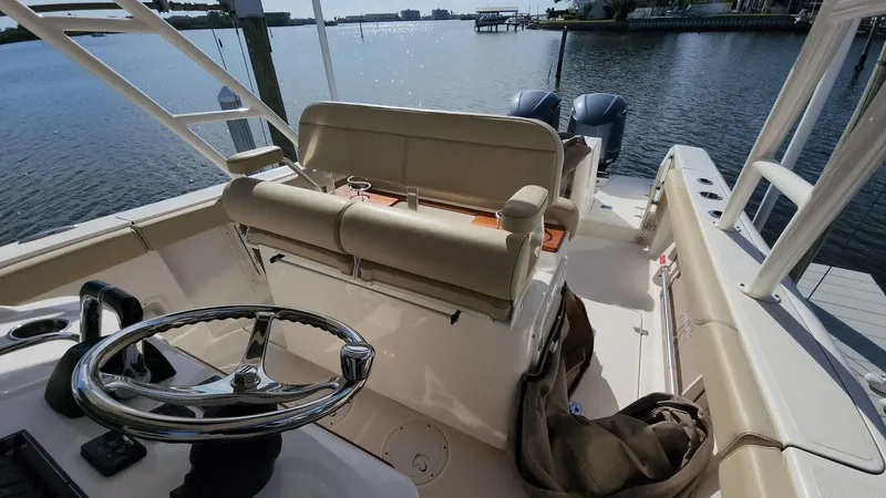 Slide: The Image of 2017 Pursuit S 280 Sport boat interior with steering wheel and seating, overlooking calm waters. - 48