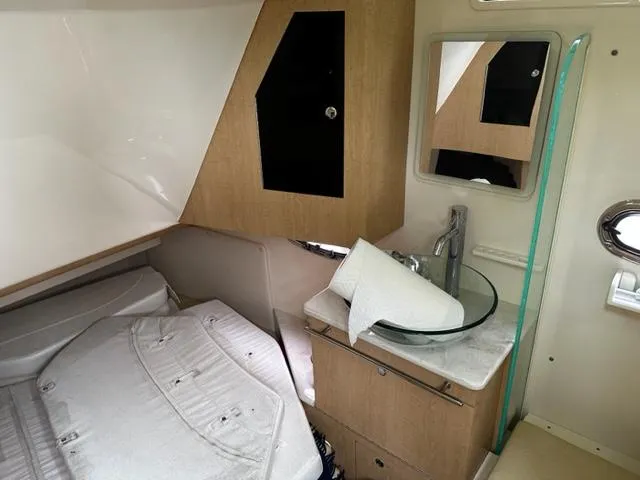 Slide: The Image of 2014 Boston Whaler 370 Outrage cabin interior with bed and sink. - 10