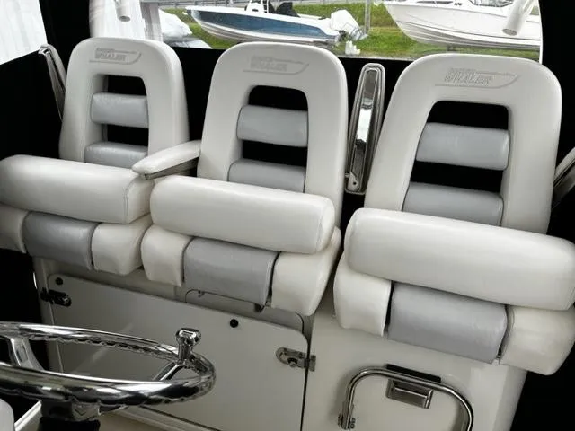 Slide: The Image of 2014 Boston Whaler 370 Outrage helm seats, white and gray, luxury boat interior. - 11