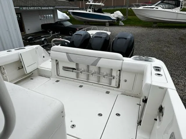 Slide: The Image of 2014 Boston Whaler 370 Outrage boat with triple outboard engines in a marina. - 3