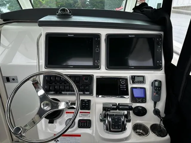 Slide: The Image of 2014 Boston Whaler 370 Outrage helm with dual Raymarine displays and advanced controls. - 8