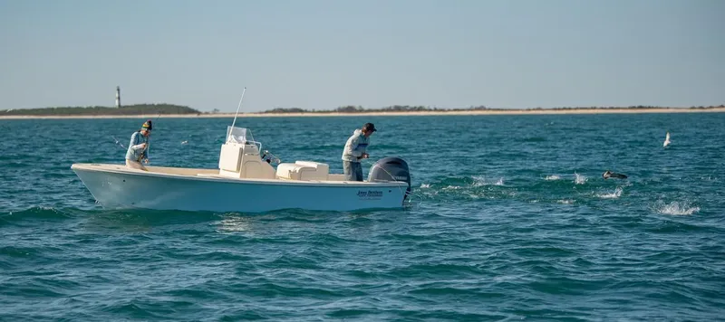 Slide: The Image of 2024 Jones Brothers Cape Fisherman 23 boat on the ocean with a person fishing. - 10
