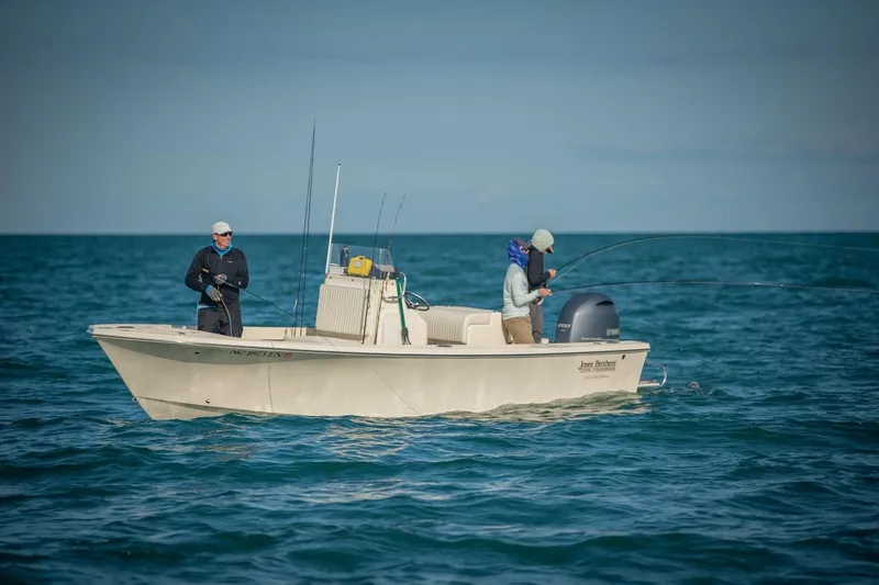 Slide: The Image of 2024 Jones Brothers Cape Fisherman 23 boat on the water with two people fishing. - 11