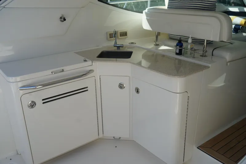 Slide: The Image of 2010 Sea Ray 470 Sundancer yacht kitchenette with sink and storage cabinets. - 12