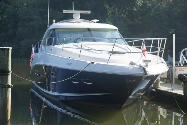 Slide: The Image of 2010 Sea Ray 470 Sundancer yacht docked in a serene marina setting. - 2