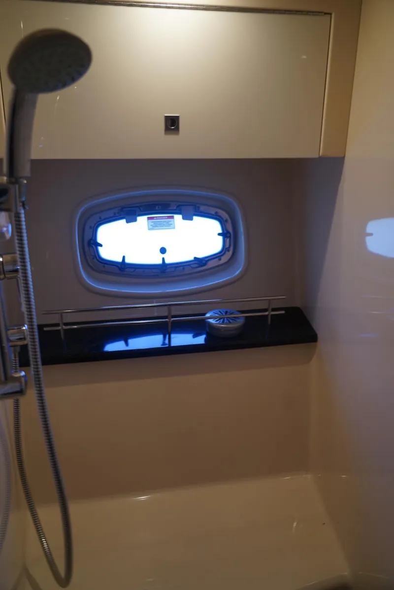 Slide: The Image of 2010 Sea Ray 470 Sundancer bathroom with shower and porthole window. - 24