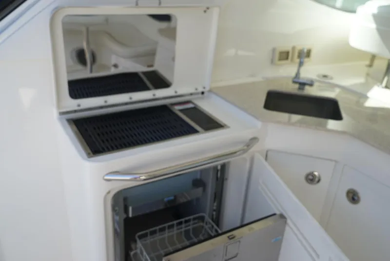 Slide: The Image of 2010 Sea Ray 470 Sundancer yacht interior with open fridge and sink. - 25