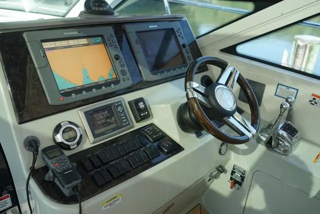 Slide: The Image of 2010 Sea Ray 470 Sundancer helm with navigation screens and steering wheel. - 7