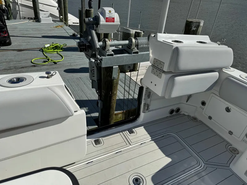 Slide: The Image of 2019 HCB Siesta boat interior at dock, featuring white cushioned seating and deck. - 17