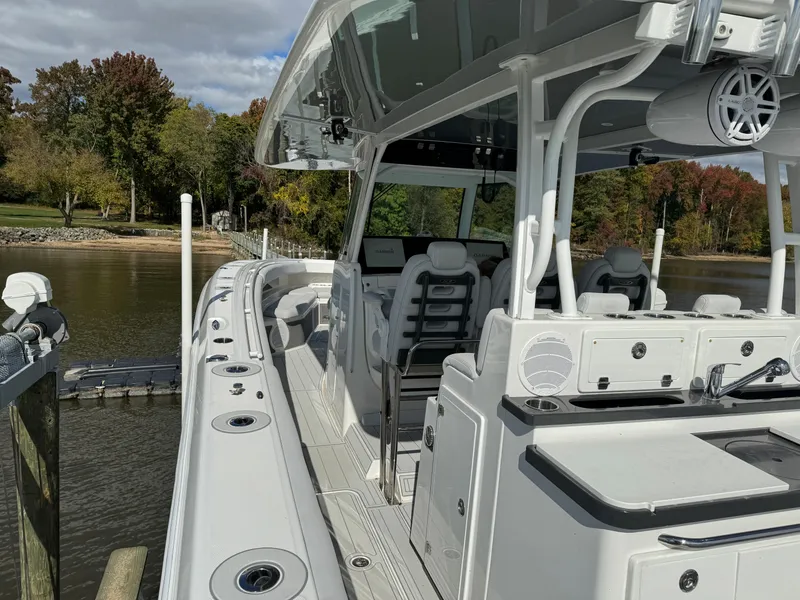 Slide: The Image of 2019 HCB Siesta boat docked by a lake with lush trees in the background. - 18