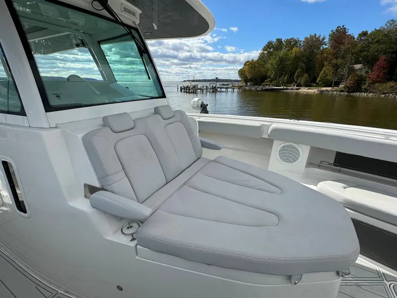 Slide: The Image of 2019 HCB Siesta boat with cushioned seating, docked by a scenic waterfront. - 46