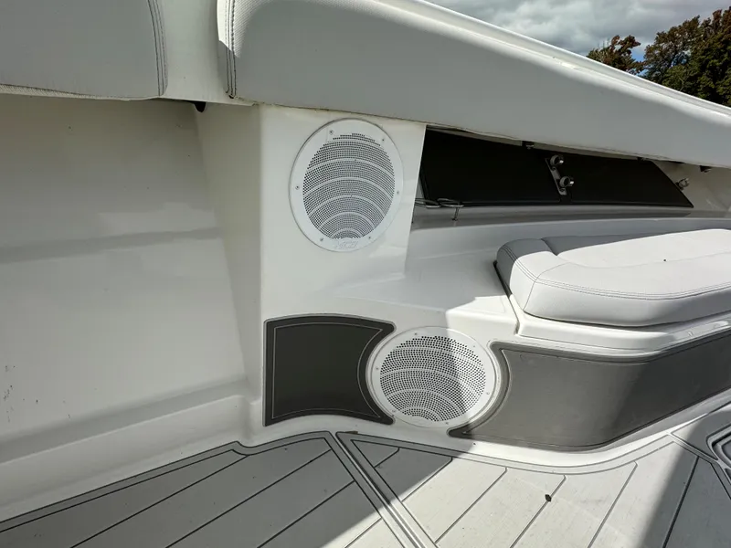 Slide: The Image of 2019 HCB Siesta boat interior with white and gray seating and built-in speakers. - 49