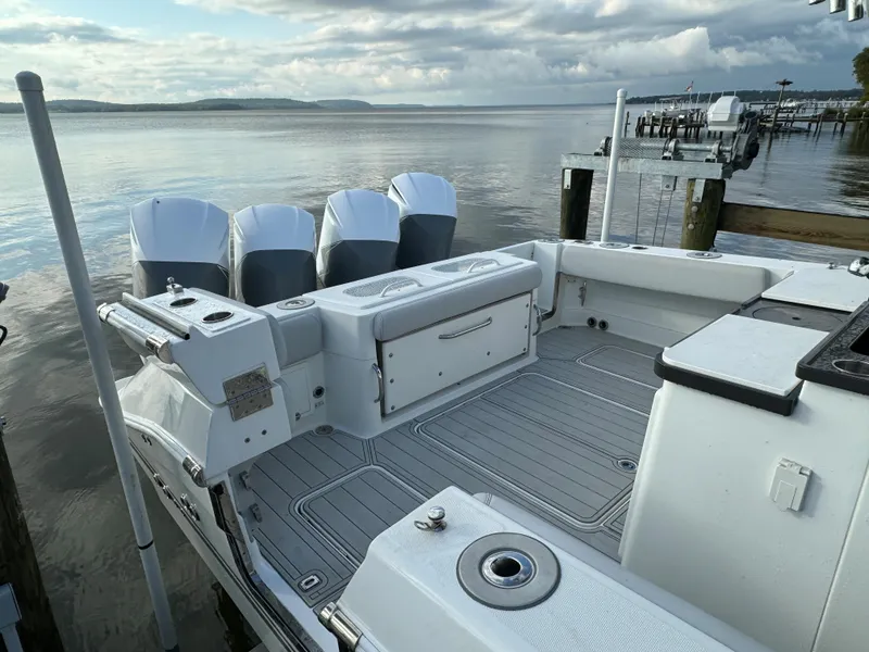 Slide: The Image of 2019 HCB Siesta boat with quad outboard engines docked by the water. - 6