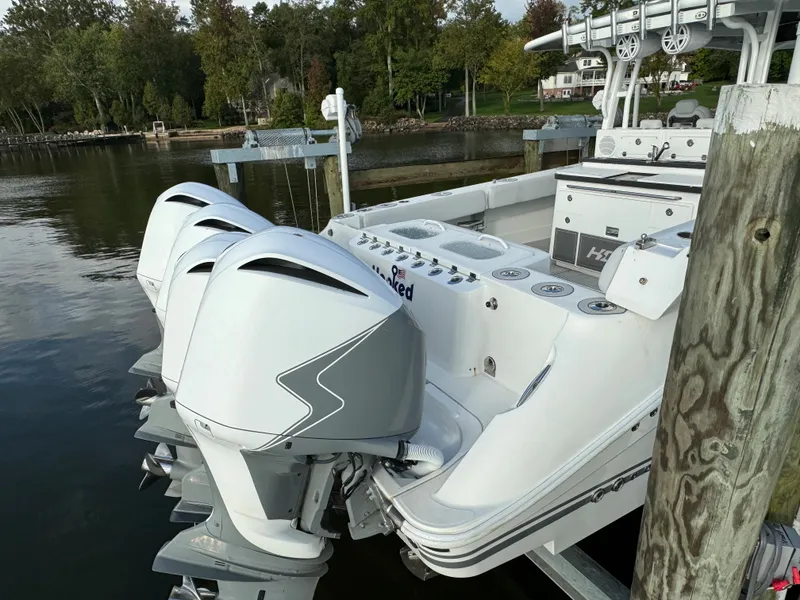 Slide: The Image of 2019 HCB Siesta boat with triple outboard engines docked by a lake. - 8