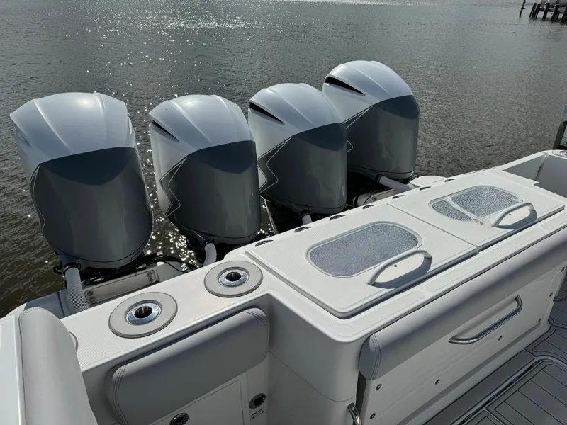 Slide: The Image of 2019 HCB Siesta boat with four powerful outboard engines on a calm water backdrop. - 10