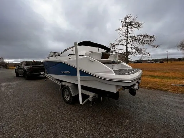 Slide: The Image of 2014 Scarab 215 boat on trailer, parked on a cloudy day. - 3