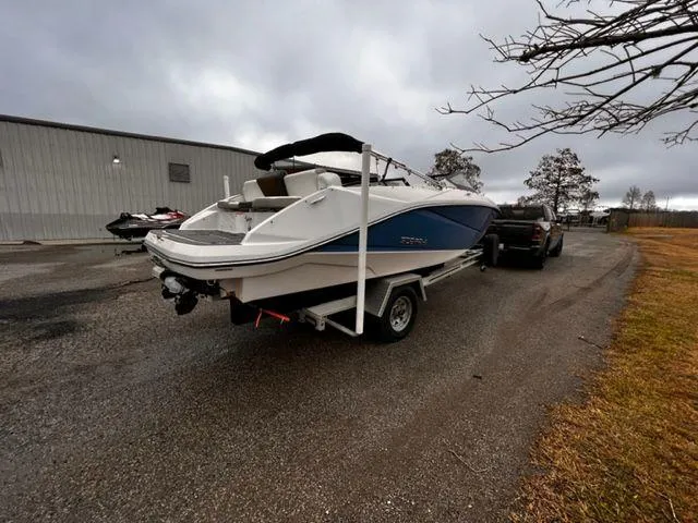 Slide: The Image of 2014 Scarab 215 boat on trailer, parked outdoors near a building. - 4