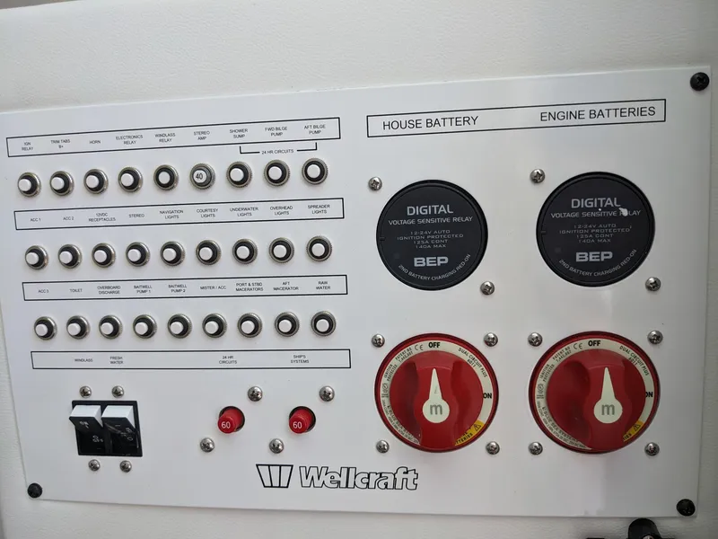 Slide: The Image of Control panel of 2024 Wellcraft 302 Fisherman boat with battery switches and digital displays. - 13