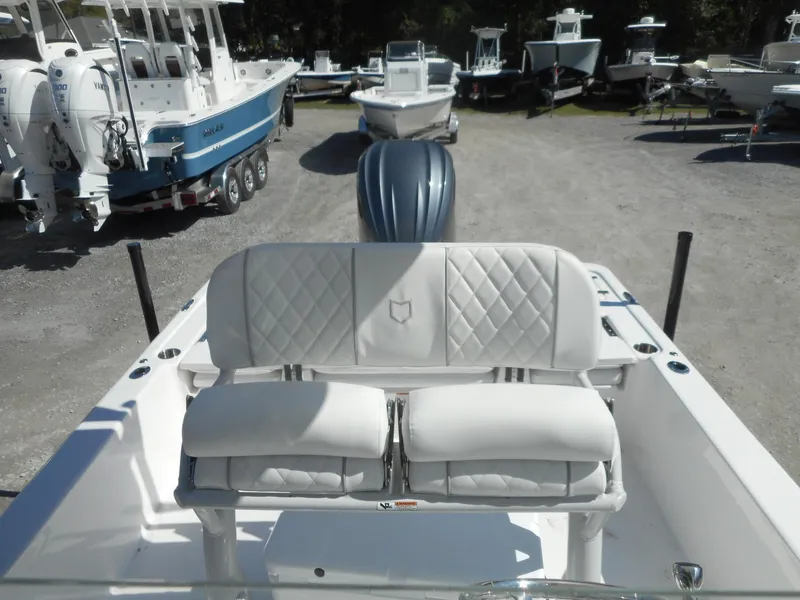 Slide: The Image of 2024 Sea Fox 251 BAYFOX boat with white cushioned seating and outboard motor. - 18