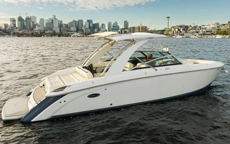Slide: The Image of 2018 Cobalt 30 R boat cruising on water with city skyline in the background. - 17