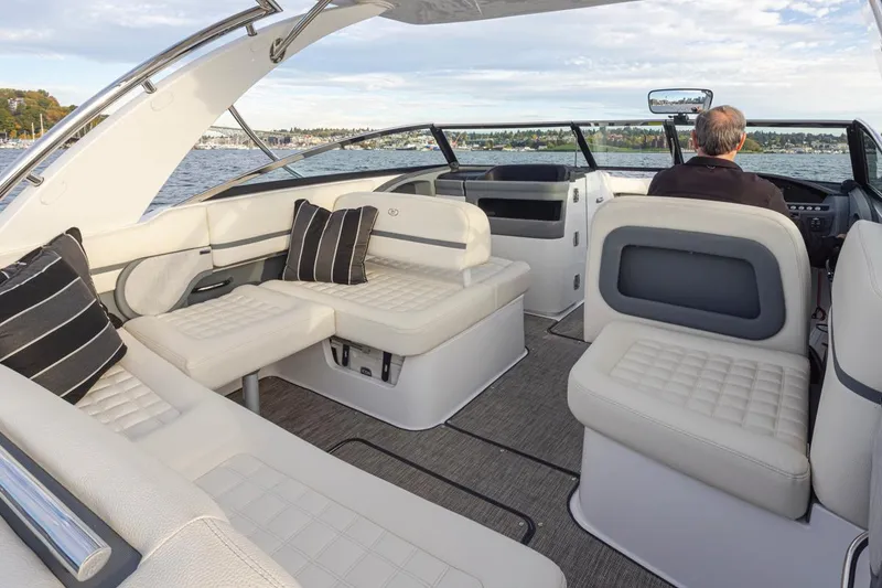 Slide: The Image of 2018 Cobalt 30 R boat interior with white seating and black cushions on the water. - 24