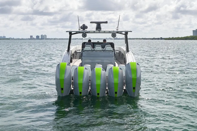 Slide: The Image of 2022 Midnight Express 43' Solstice boat with five green-accented outboard motors on open water. - 10