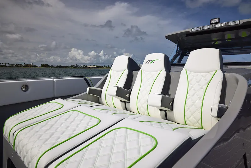 Slide: The Image of Luxury seating on 2022 Midnight Express 43' Solstice boat, featuring white and green accents. - 12