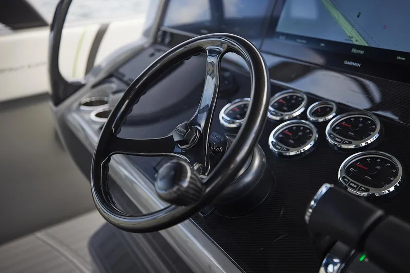 Slide: The Image of Steering wheel and dashboard of 2022 Midnight Express 43' Solstice boat, featuring modern gauges. - 17