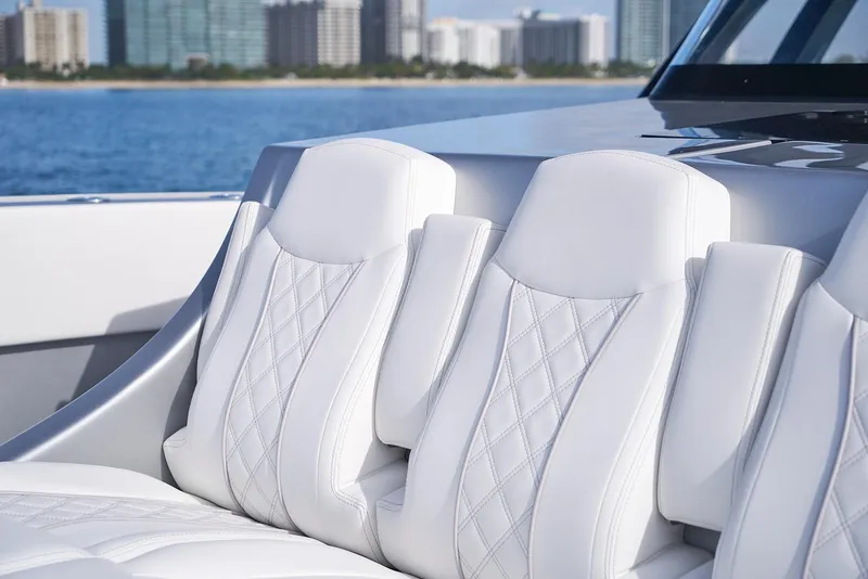 Slide: The Image of Luxurious white seating on a 2021 Midnight Express 43' Open boat with cityscape background. - 10