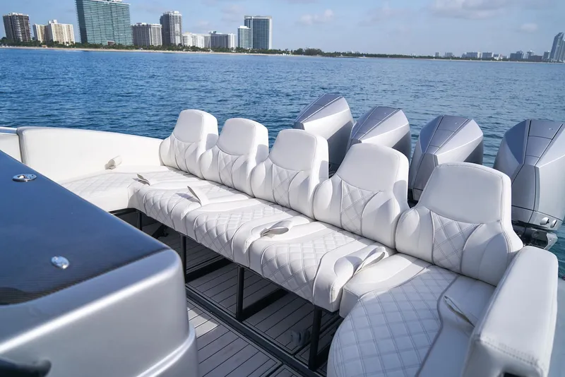 Slide: The Image of Luxury seating on a 2021 Midnight Express 43' Open boat with ocean and cityscape background. - 21