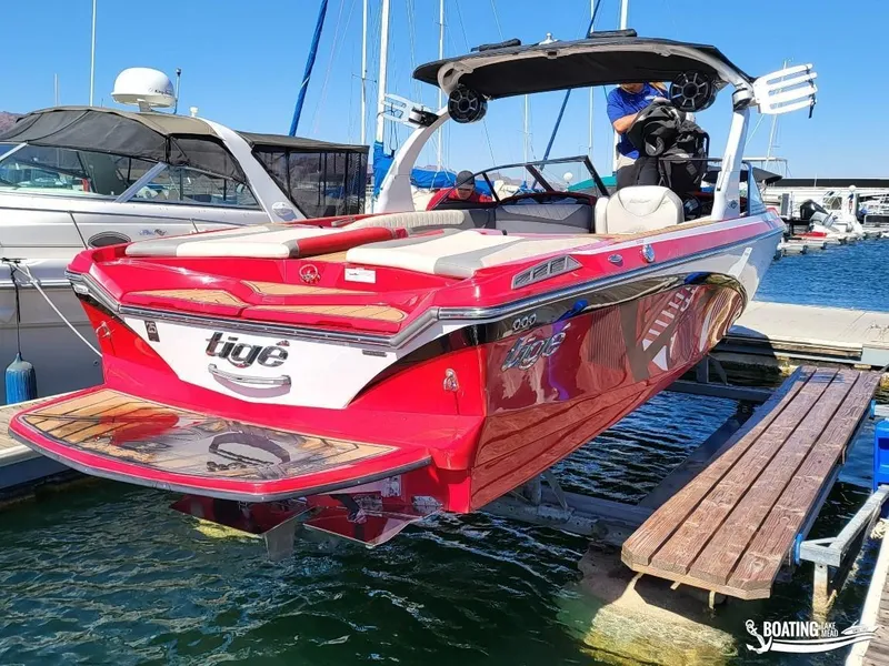 Slide: The Image of 2016 Tigé Z3 boat docked at marina, vibrant red and white design. - 10