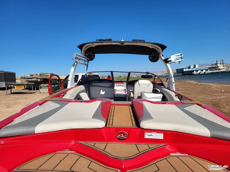 Slide: The Image of 2016 Tigé Z3 boat with red and gray interior, parked near a lake under clear blue skies. - 13