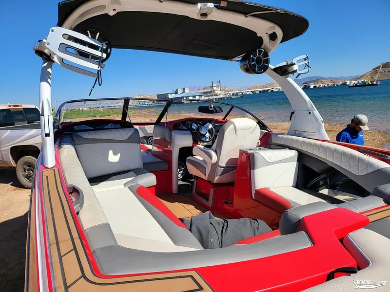 Slide: The Image of 2016 Tigé Z3 boat interior with red and gray seating, parked by a lake. - 18