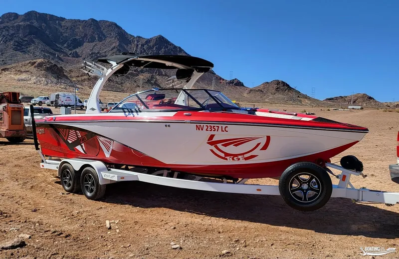 Slide: The Image of 2016 Tigé Z3 boat on trailer, red and white design, desert landscape background. - 2