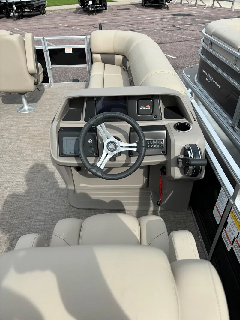 Slide: The Image of 2024 Sun Tracker SportFish 20 DLX pontoon boat interior with steering console and seating. - 5