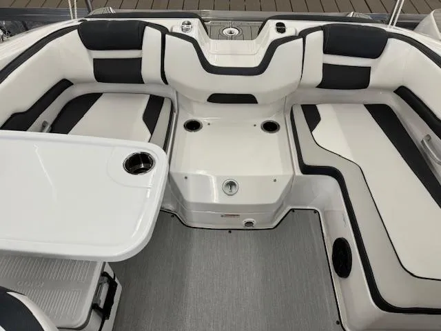 Slide: The Image of 2024 Yamaha Boats SX195 interior seating area with table and cup holders. - 16
