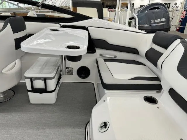 Slide: The Image of 2024 Yamaha Boats SX195 interior with seating, table, and cooler. - 18