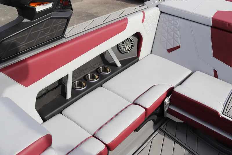 Slide: The Image of 2024 Nautique GS22 boat interior with red and white seating and cup holders. - 12