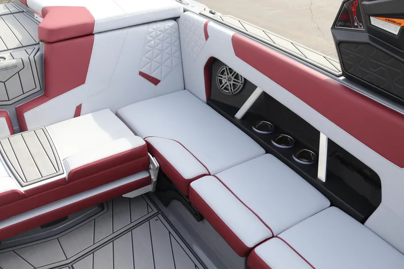 Slide: The Image of 2024 Nautique GS22 boat interior with red and white upholstery and cup holders. - 13