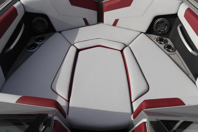 Slide: The Image of 2024 Nautique GS22 boat interior with red and white upholstery and cup holders. - 17