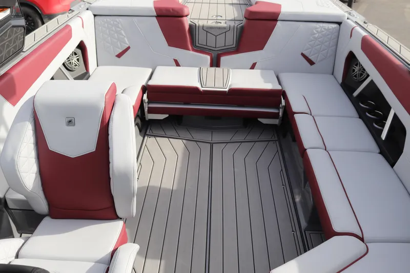 Slide: The Image of 2024 Nautique GS22 boat interior with red and white seating and grey flooring. - 19