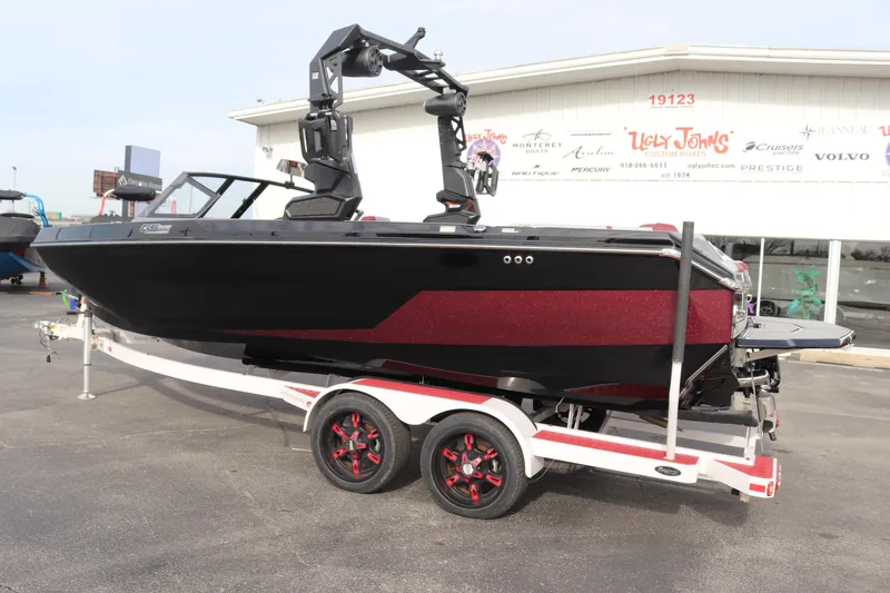 Slide: The Image of 2024 Nautique GS22 boat on a trailer, black and red exterior. - 4