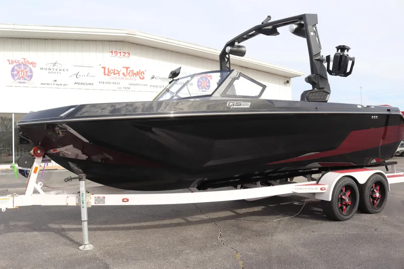Slide: The Image of 2024 Nautique GS22 boat on trailer, black and red, outside dealership. - 5
