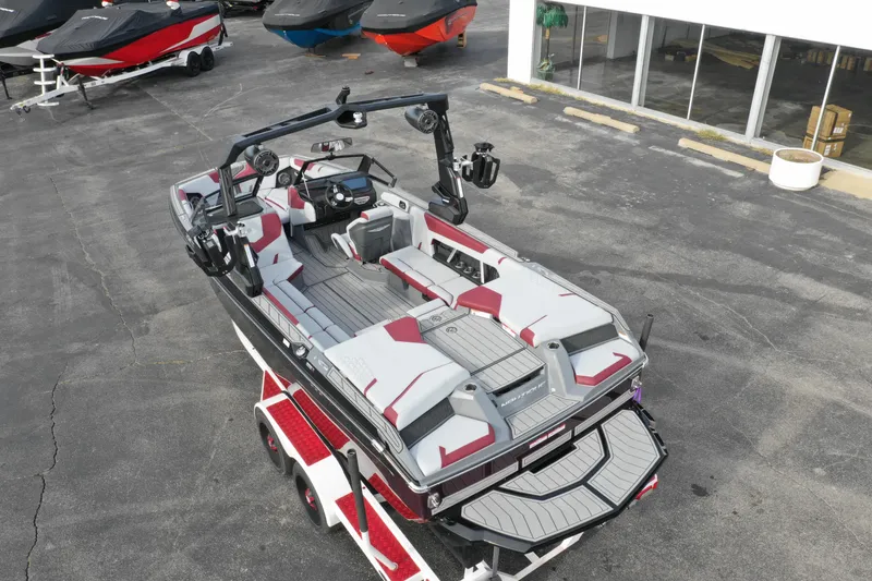 Slide: The Image of 2024 Nautique GS22 boat with red and gray interior on a trailer. - 7