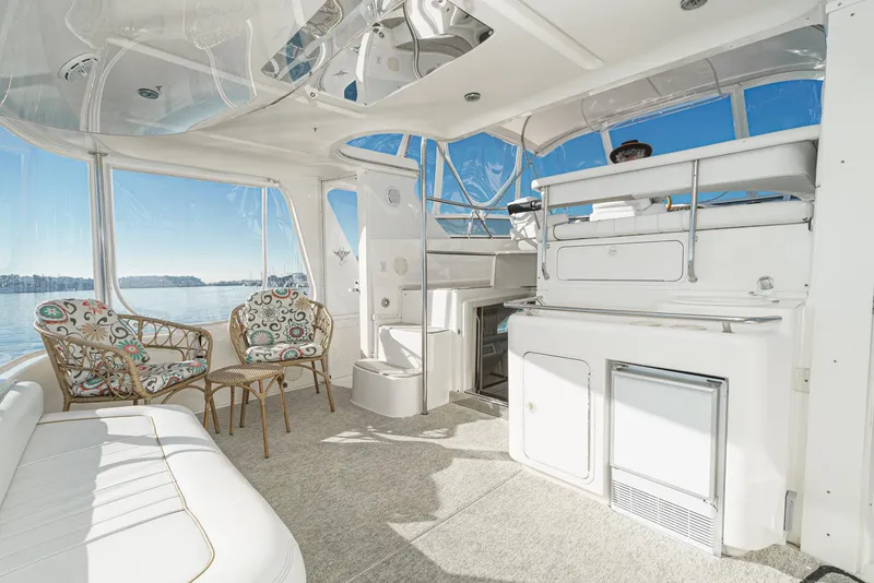 Slide: The Image of 1997 Sea Ray 420 Aft Cabin interior with seating and kitchenette, panoramic windows. - 2