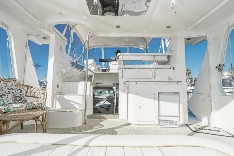 Slide: The Image of 1997 Sea Ray 420 Aft Cabin yacht interior with white furnishings and marina view. - 20