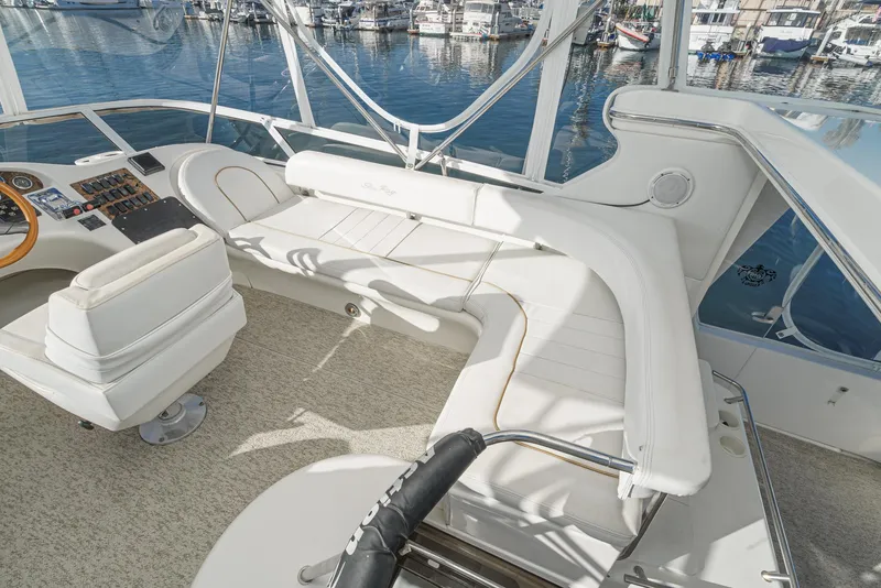 Slide: The Image of 1997 Sea Ray 420 Aft Cabin yacht interior with white seating and helm station. - 24
