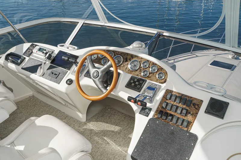 Slide: The Image of 1997 Sea Ray 420 Aft Cabin helm with wooden steering wheel and control panel. - 26